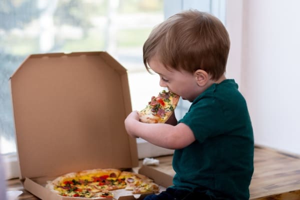 child slowly eating pizza just like how you should eat an elephant